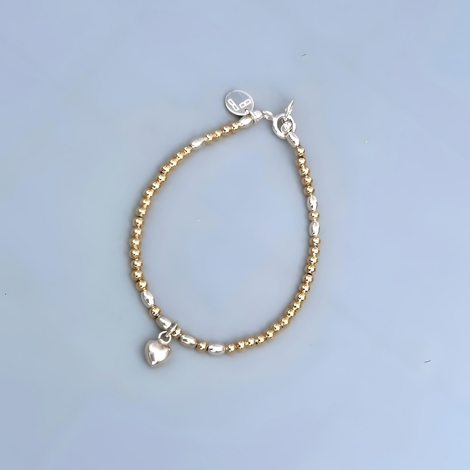 The LeBijouBijou Streak of Gold Bracelet made with rosé gold sterling silver and a heart shaped charm.