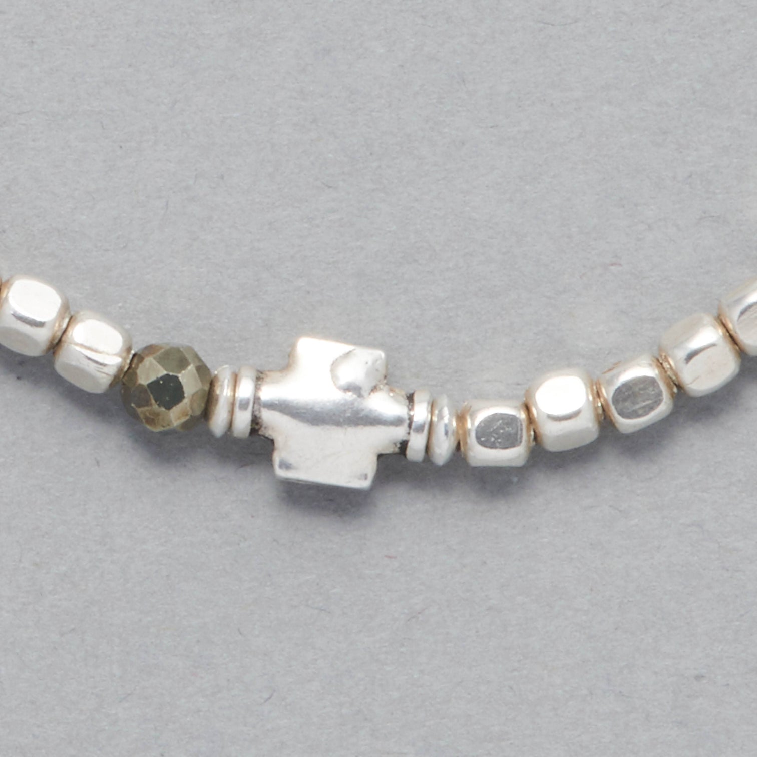 Close-up of the Ceres Bracelet strung with faceted Pyrite beads, octagonal sterling silver beads and as a center piece a sterling silver element.