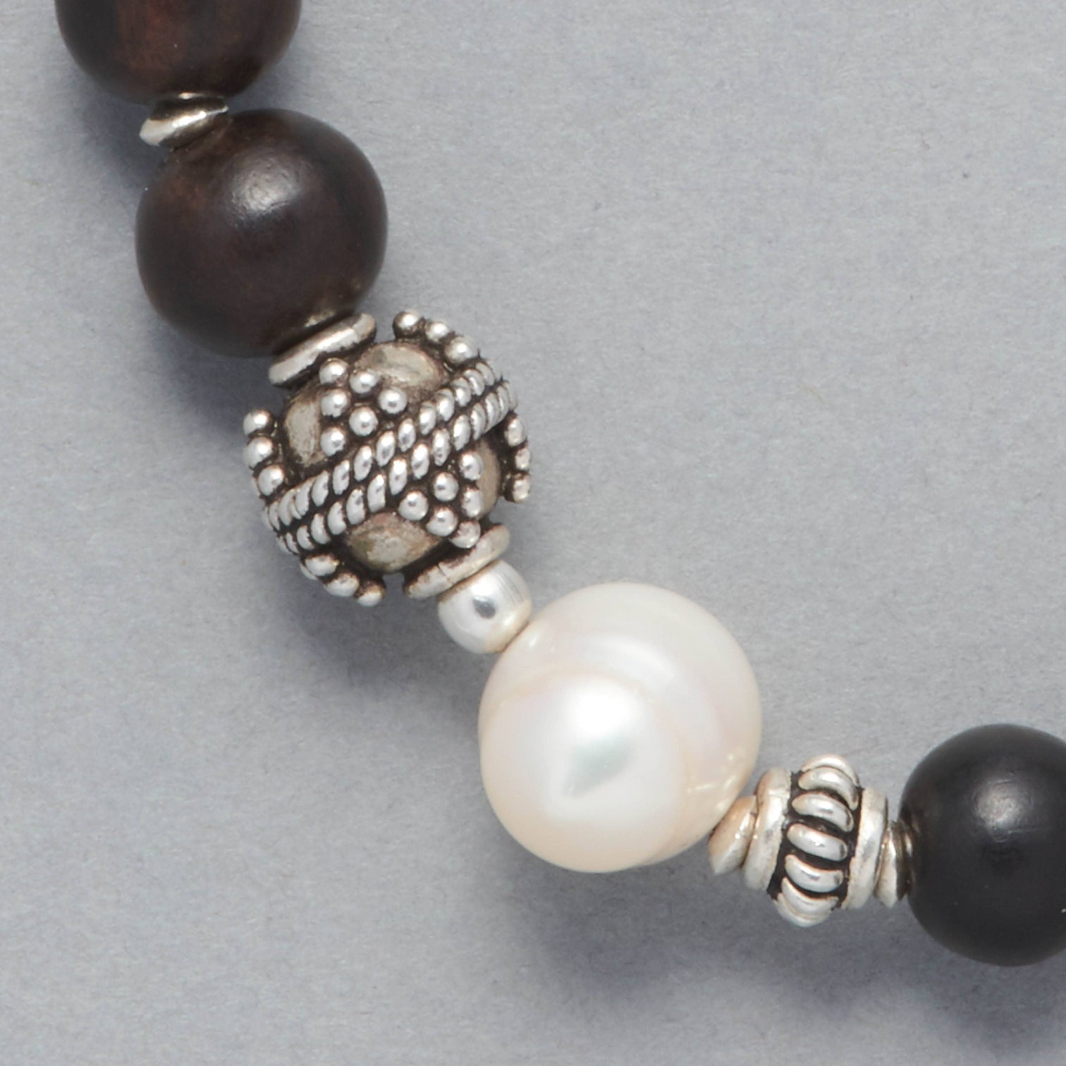Close-up of the Ebony Bracelet made with Ebony Wood, a Cultured Freshwater Pearl and Sterling Silver Elements.