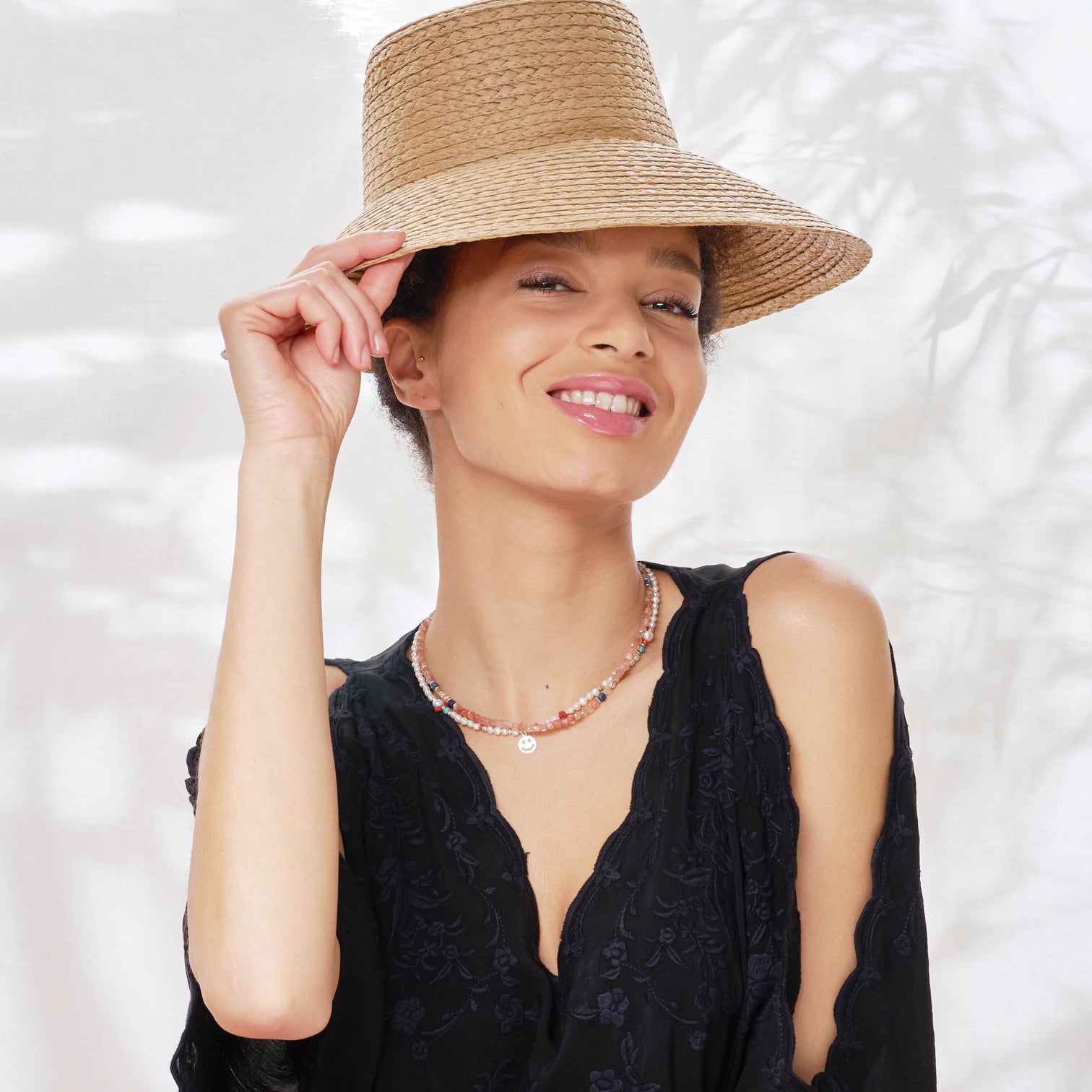 Female Model is wearing the Ginger Necklace made with faceted square Sunstones and the Alaia Necklace made with Freshwater White Pearls and a Smiley charm. 