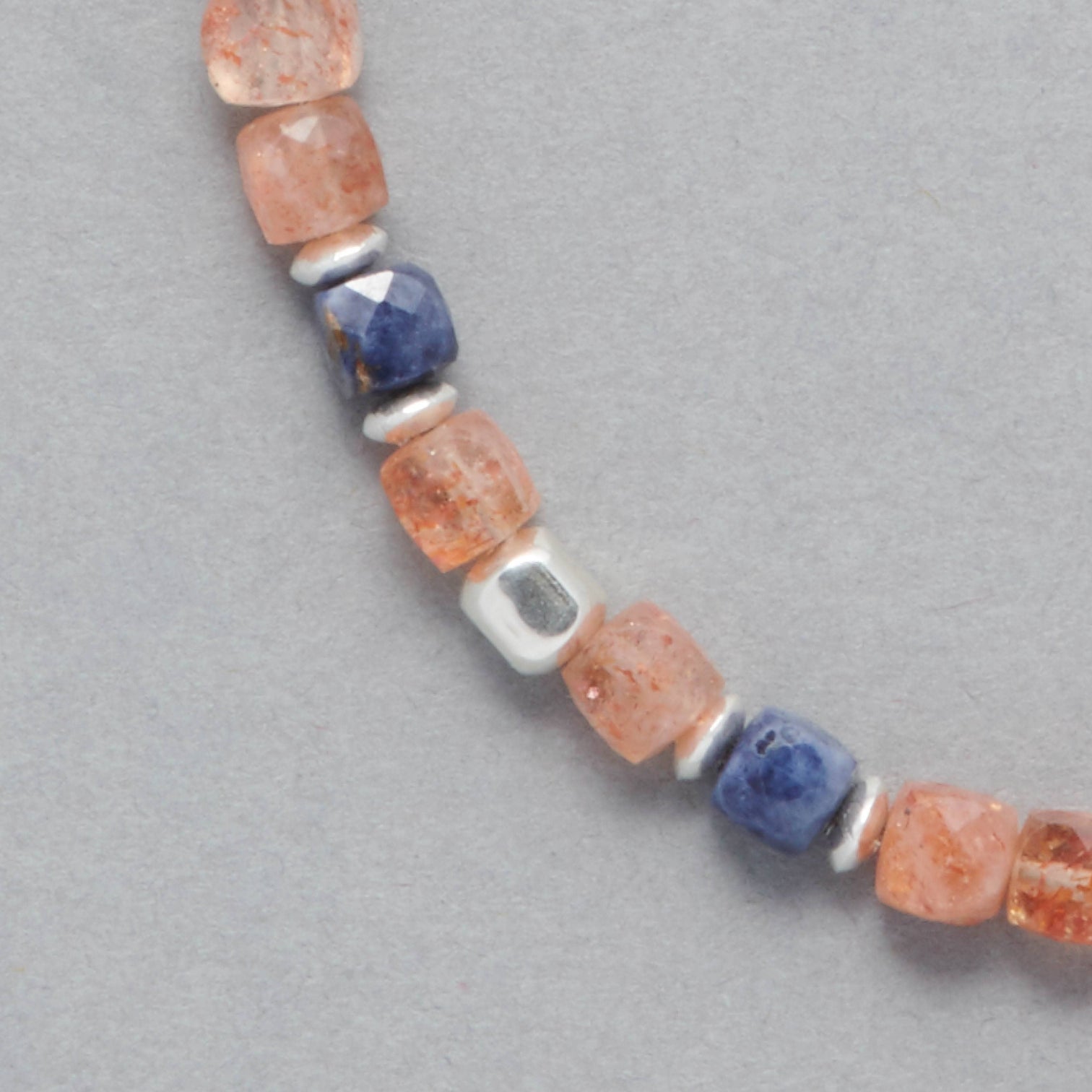 Detail shot of the Ginger Necklace made with faceted square Sunstones, faceted square Sapphires and Sterling Silver elements. 