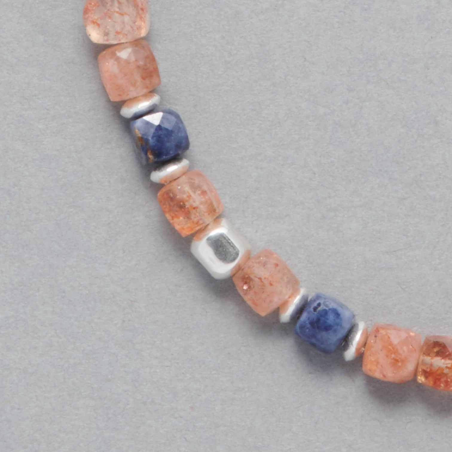Detail shot of the Ginger Necklace made with faceted square Sunstones, faceted square Sapphires and Sterling Silver elements.