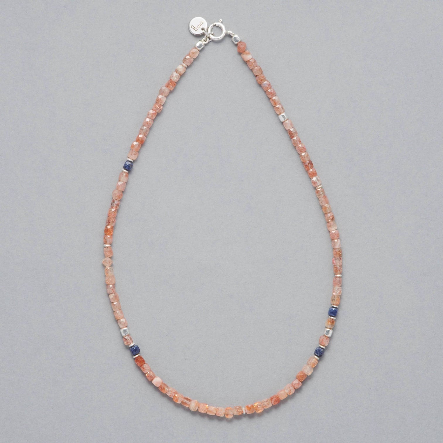 Product shot of the Ginger Necklace made with faceted square Sunstones, faceted square Sapphires and Sterling Silver elements.