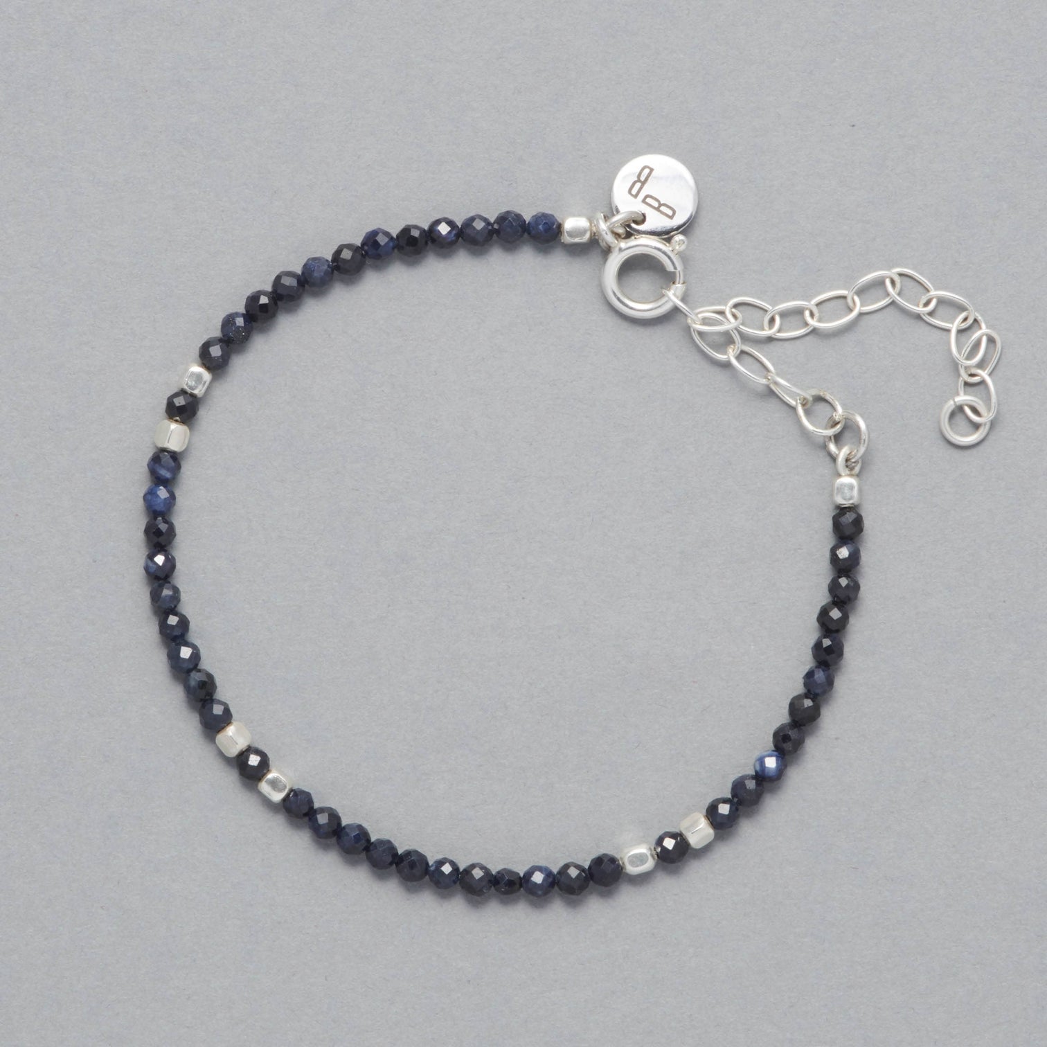 Product shot of the Indigo Anklet made with faceted Sapphires and square shaped Sterling Silver Beads.