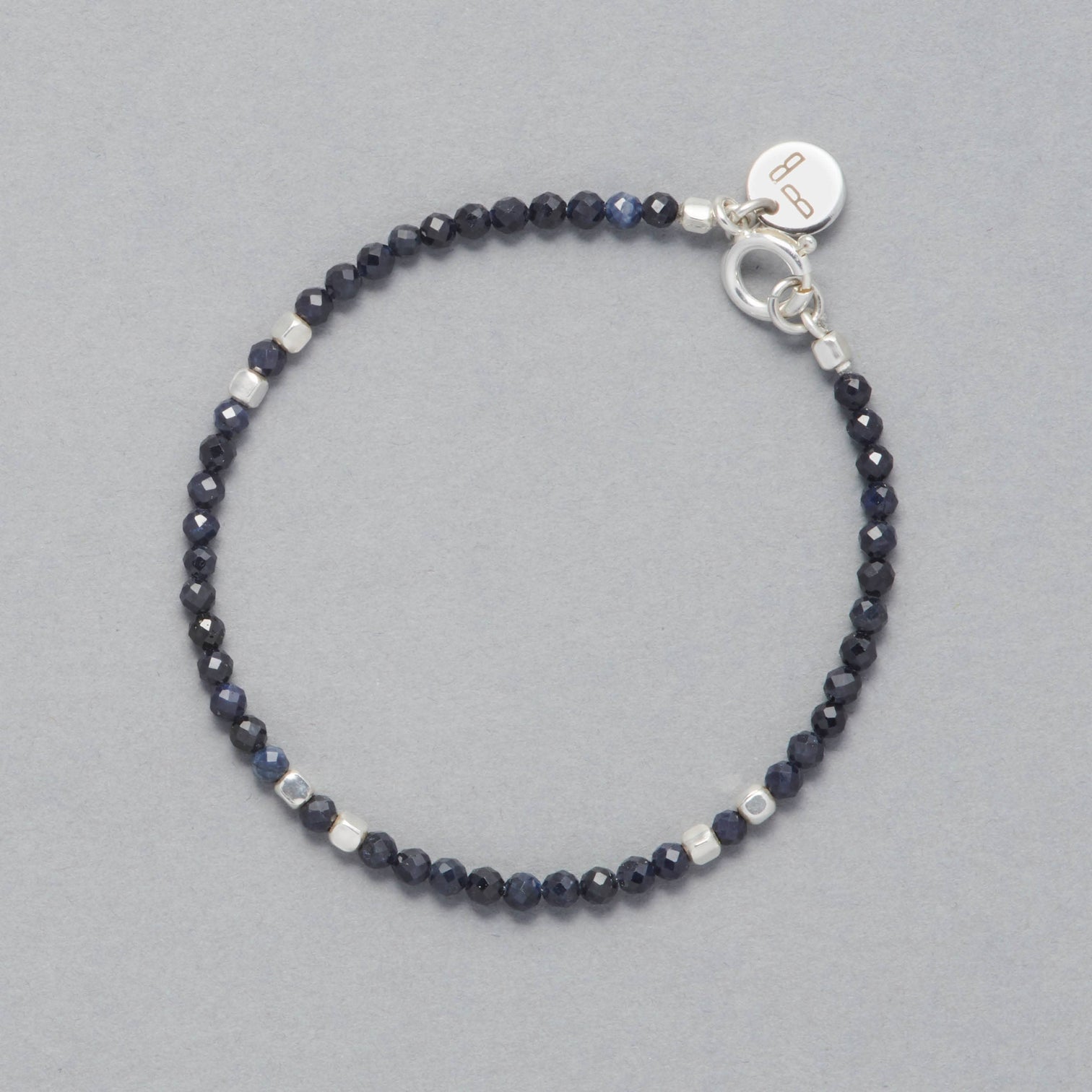 Product shot of the Indigo Bracelet made with faceted square Sapphires and square Sterling Silver Beads.