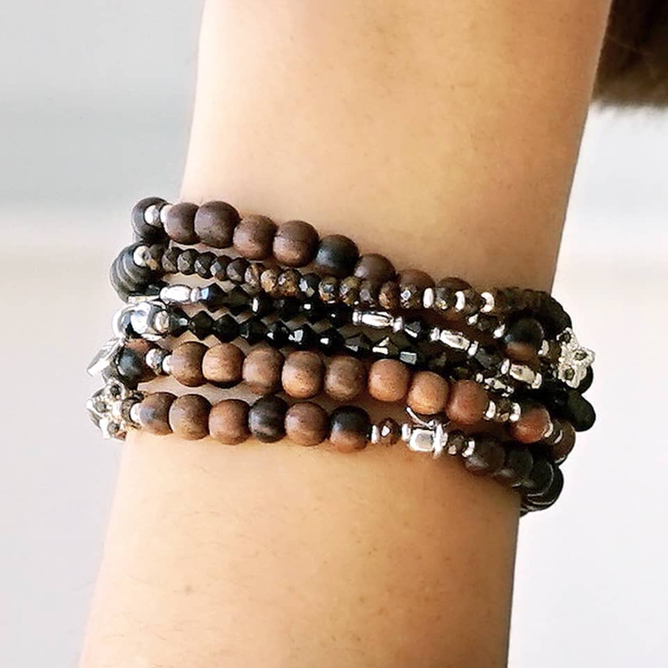 Close-up of a female model wearing LE BIJOUBIJOU JOY Double Wrap Bracelet. This double wrap bracelet is made with Ebony and Sterling Silver.  This JOY Double Wrap Bracelet is worn together with the SERENA and BRONZY Double Wrap Bracelets.