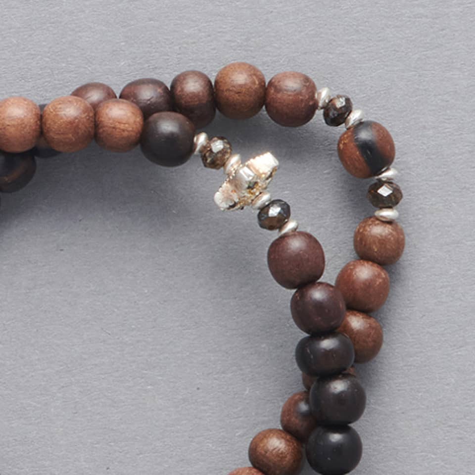 Product close-up of the LE BIJOUBIJOU JOY Double Wrap Bracelet made with Ebony and Silver faceted stars.