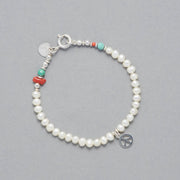 Product shot of the Marina Bracelet made with Cultured Freshwater white Pearls, faceted Turquoise, Sterling Silver Elements and a Peace Symbol Sterling Silver Peace Symbol Charm.