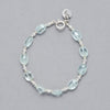 Product shot of the Zoe Bracelet made with oval-shaped Aquamarine and Sterling Silver elements. 