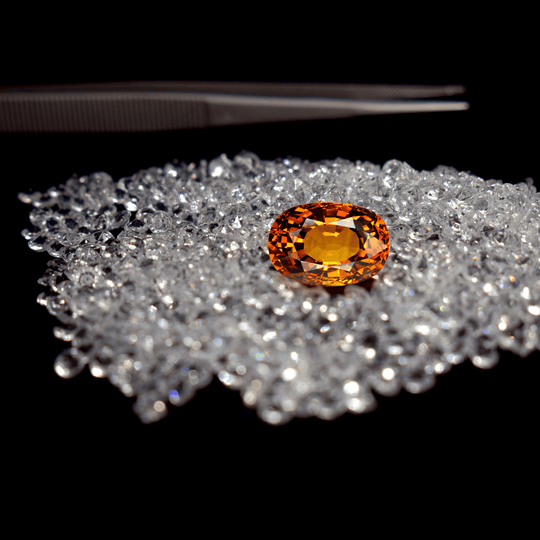 Picture for the Le BijouBijou Blog precious vs semi-precious gemstones: a topaz is on a bed of diamonds. 