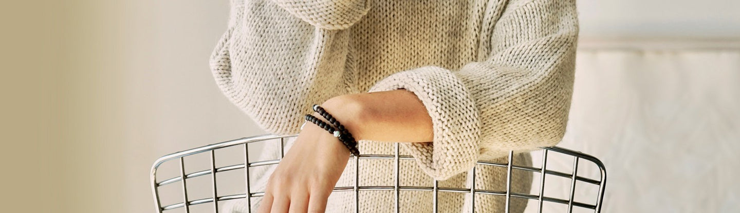 Close-Up of a female models wrist. She is wearing the LeBijouBijou KAIA Double Wrap Bracelet made with Ebony and Larimar. 