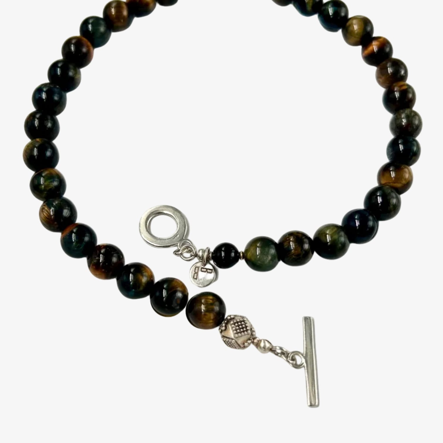 Amber Flash Necklace with round Tiger Eye beads and  an accent of a beautifully crafted silver bead next to a silver toggle clasp on clean pale grey background - Le Bijou Bijou” 