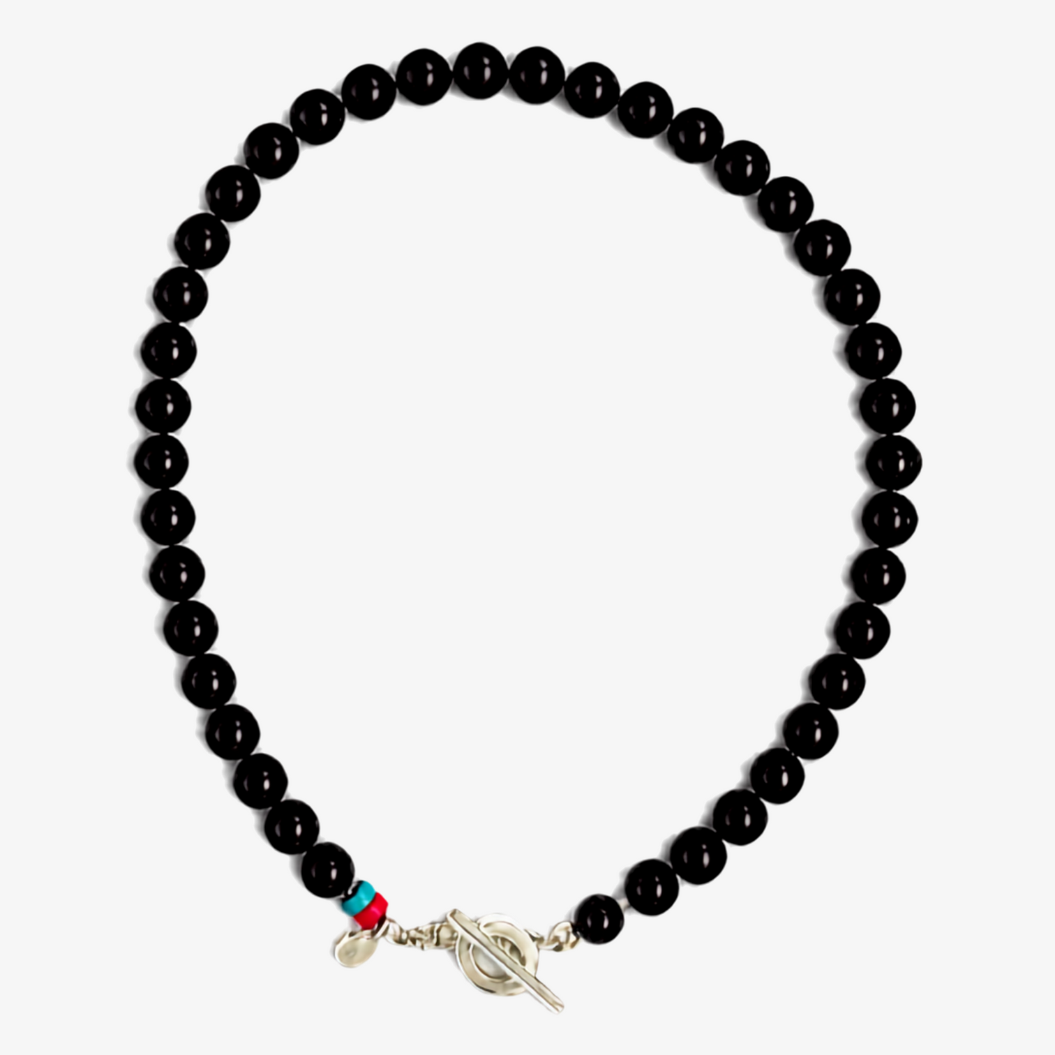 A beaded necklace with glossy black onyx beads, featuring a silver T-toggle clasp,  a crimson  and a turquoise accent bead, displayed on a very light grey background.