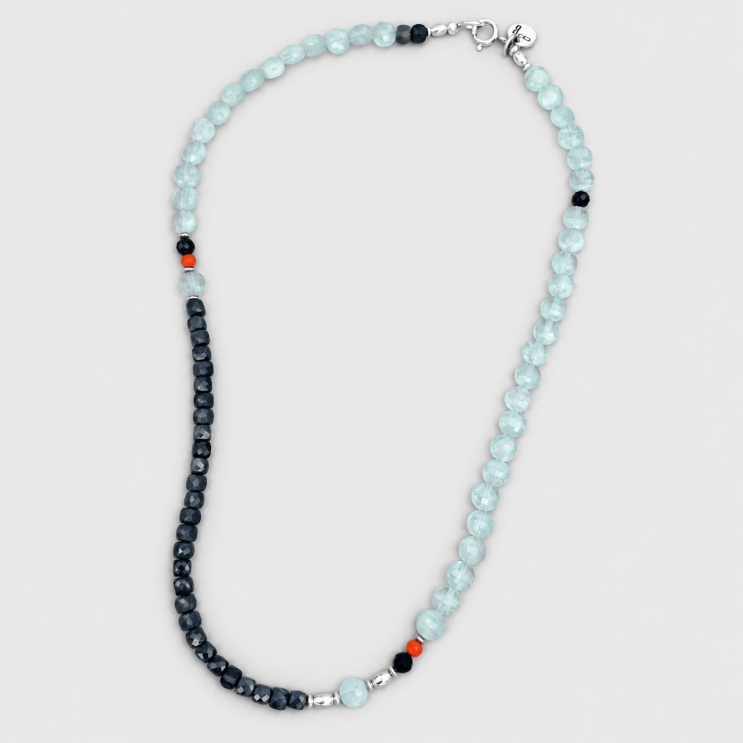 PERFECT MATCH necklace with pale-blue and dark faceted beads,corald accents and silver clasp on a neutral light-grey background.