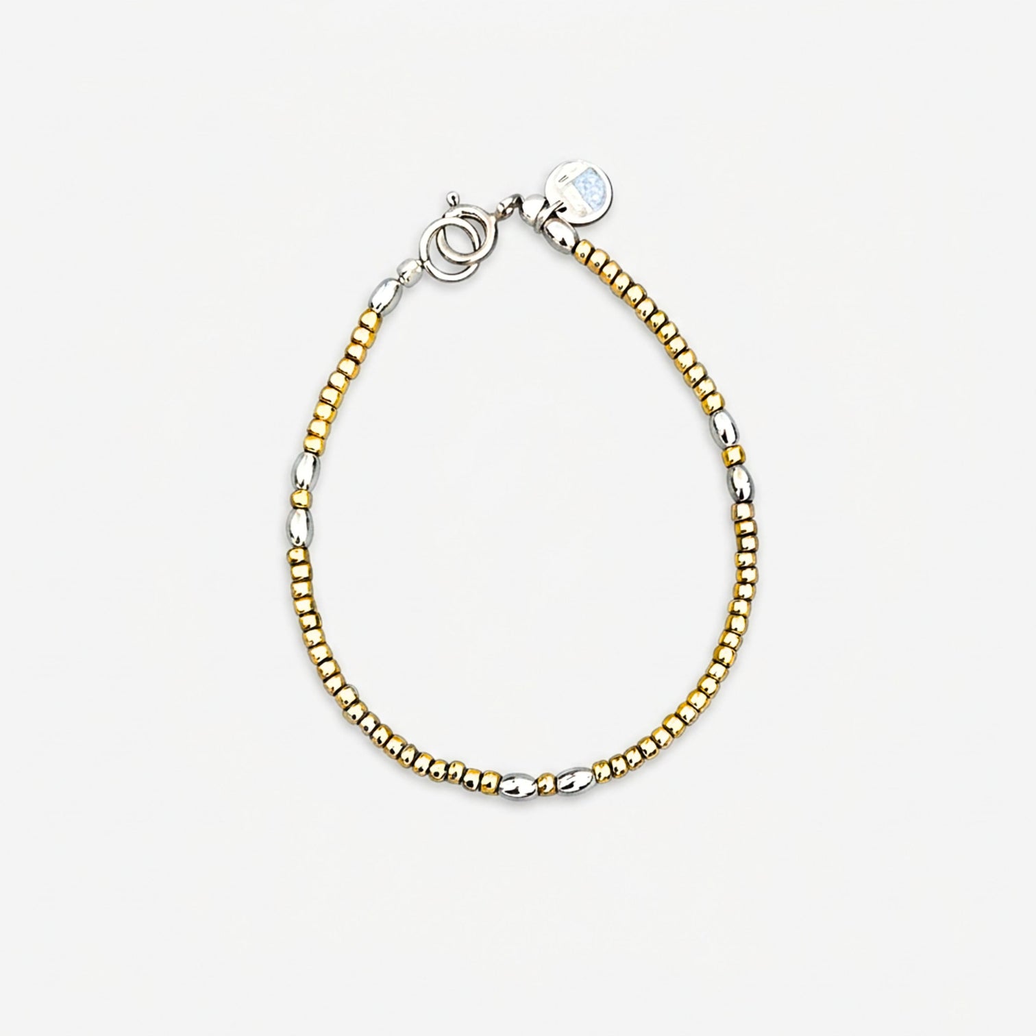The Le BijouBijou beaded bracelet features silver-plated golden beads and ellipse-shaped silver elements on a light grey background.