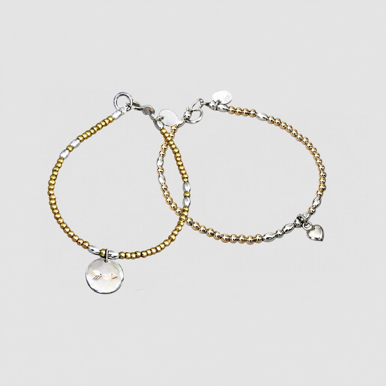 The LeBijouBijou Streak of Gold Duo Bracelets made with yellow, pink and sterling silver, presented in a light grey background.