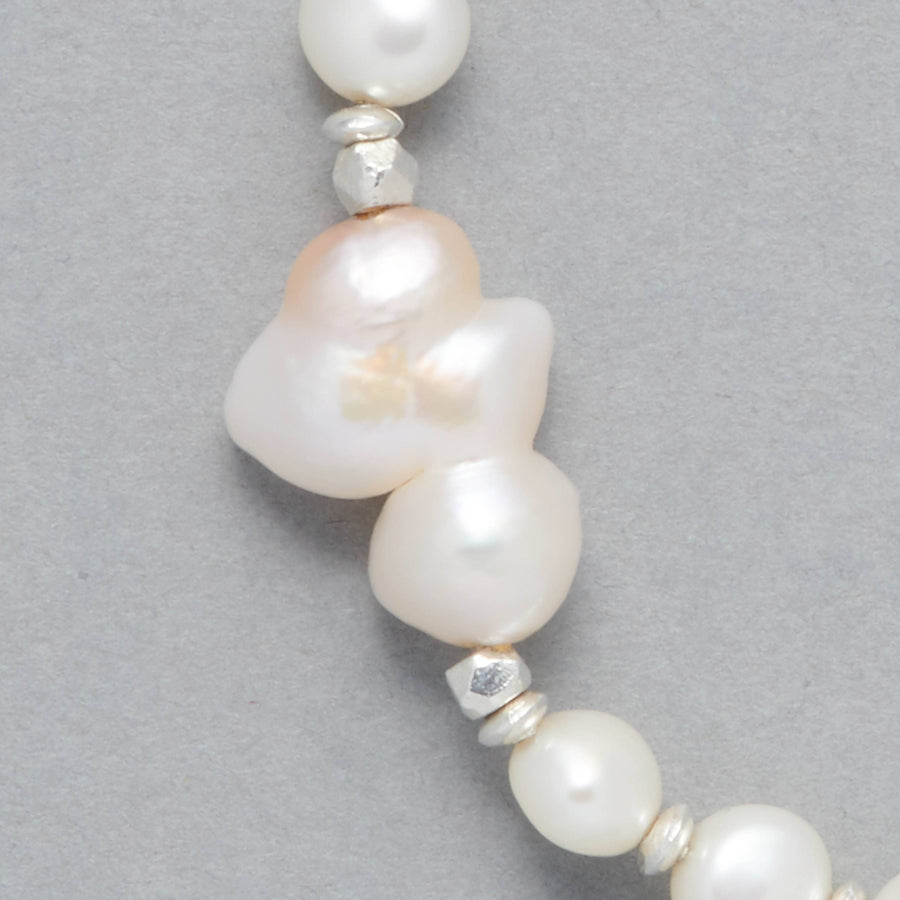 Close-Up of the BIANCA Bracelet made with Cultured Freshwater White Pearls and Silver Sterling Elements and the center-piece made with a beautiful Baroque White Pearl that is shaped like a cloud. 