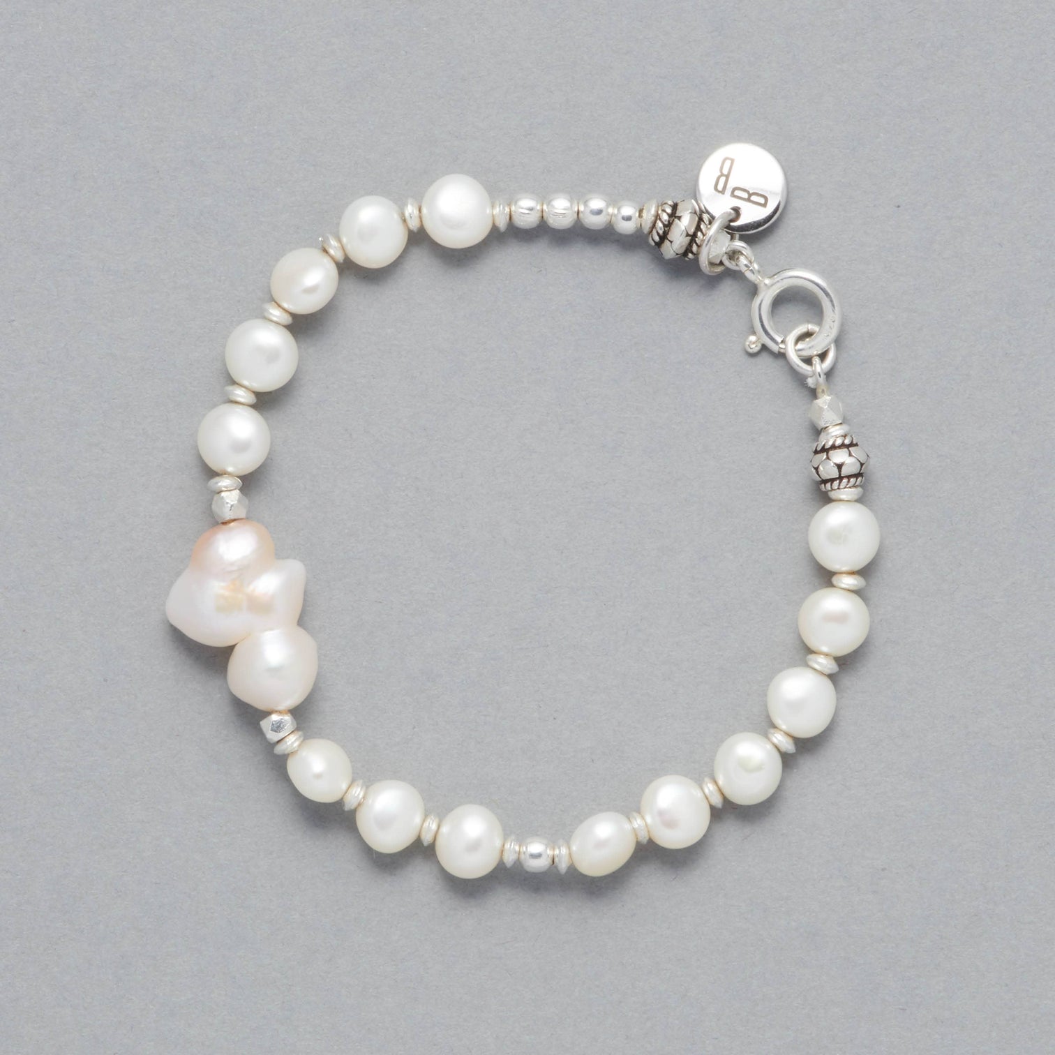 Product Shot the BIANCA Bracelet made with Cultured Freshwater White Pearls and Silver Sterling Elements. As a center-piece there is a beautiful Baroque White Pearl that is shaped like a cloud. 