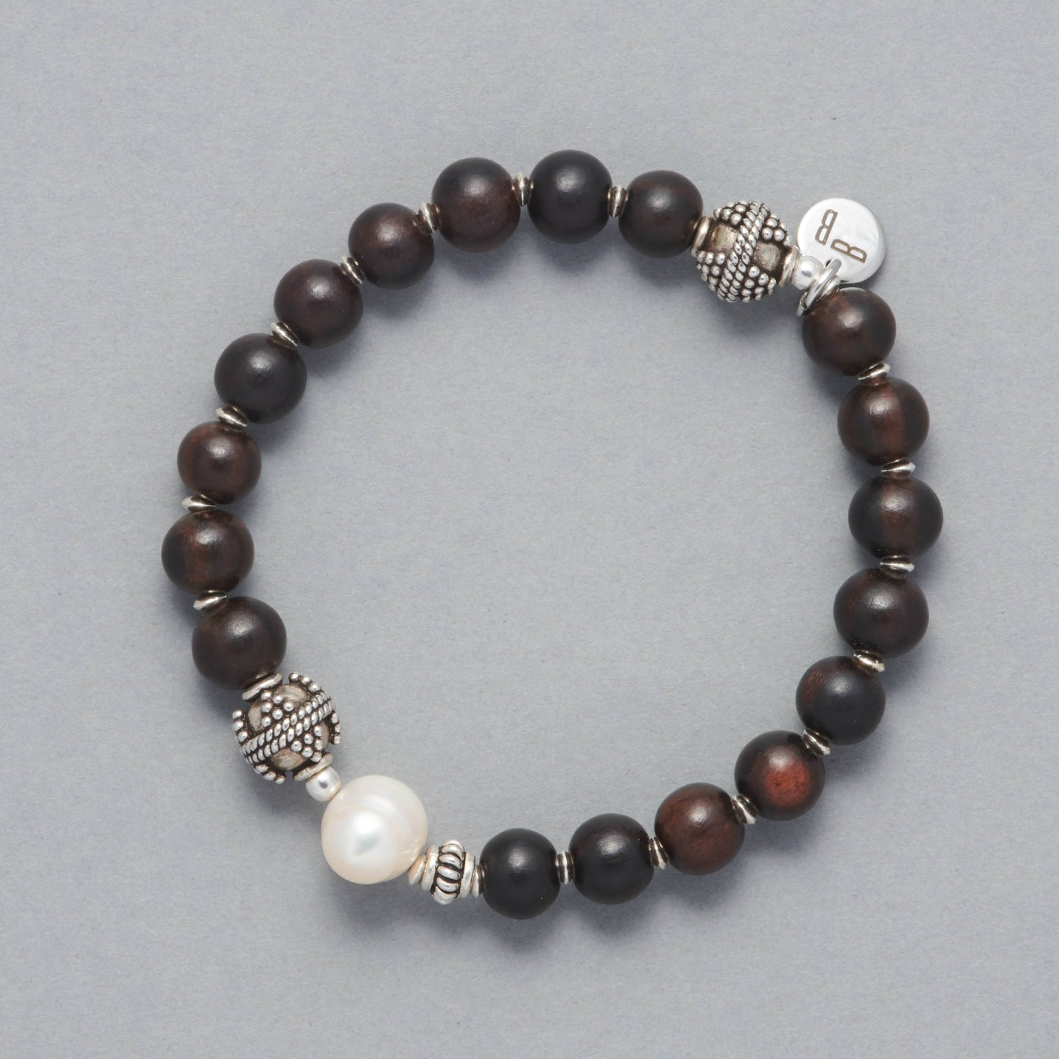 Product shot of the Ebony Bracelet made with Ebony Wood, a Cultured Freshwater Pearl and Sterling Silver Elements.