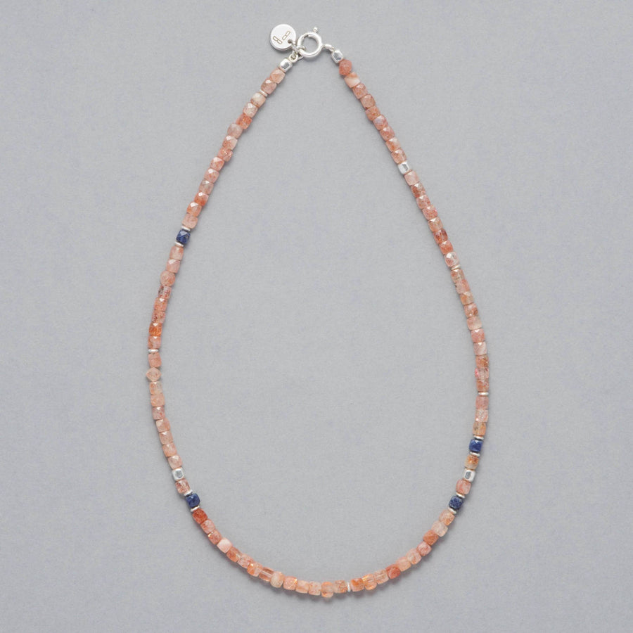 Product shot of the Ginger Necklace made with faceted square Sunstones, faceted square Sapphires and Sterling Silver elements. 