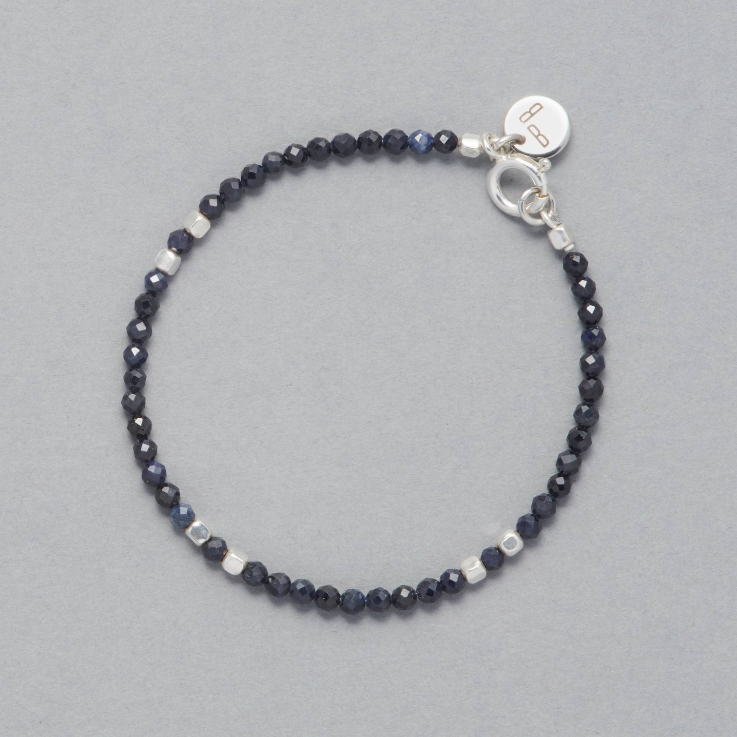 Product shot of the Indigo Bracelet made with faceted square Sapphires and square Sterling Silver Beads. 
