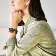 Side view of a female model wearing LE BIJOUBIJOU BRONZY Double Wrap Bracelet. This double wrap bracelet is made with Swarovski Crystals and Sterling Silver.  This BRONZY Double Wrap Bracelet is worn together with the SERENA and JOY Double Wrap Bracelets. 