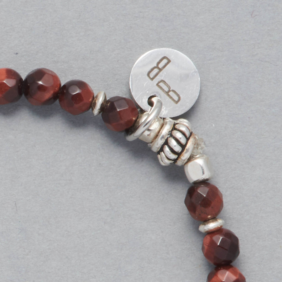 Detail of the Kim Bracelet made with faceted red Tiger Eye and Sterling Silver Beads and Element and the Le BijouBijou charm.