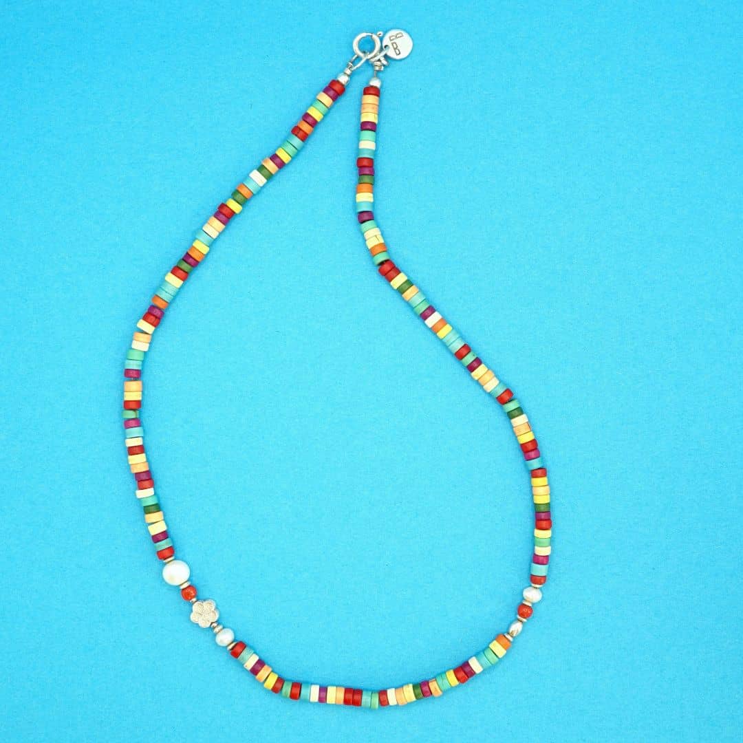 Product Shot of the Linda Necklace made with multicoloured Howlite Discs and a touch of Coral and a Freshwater Pearl. 