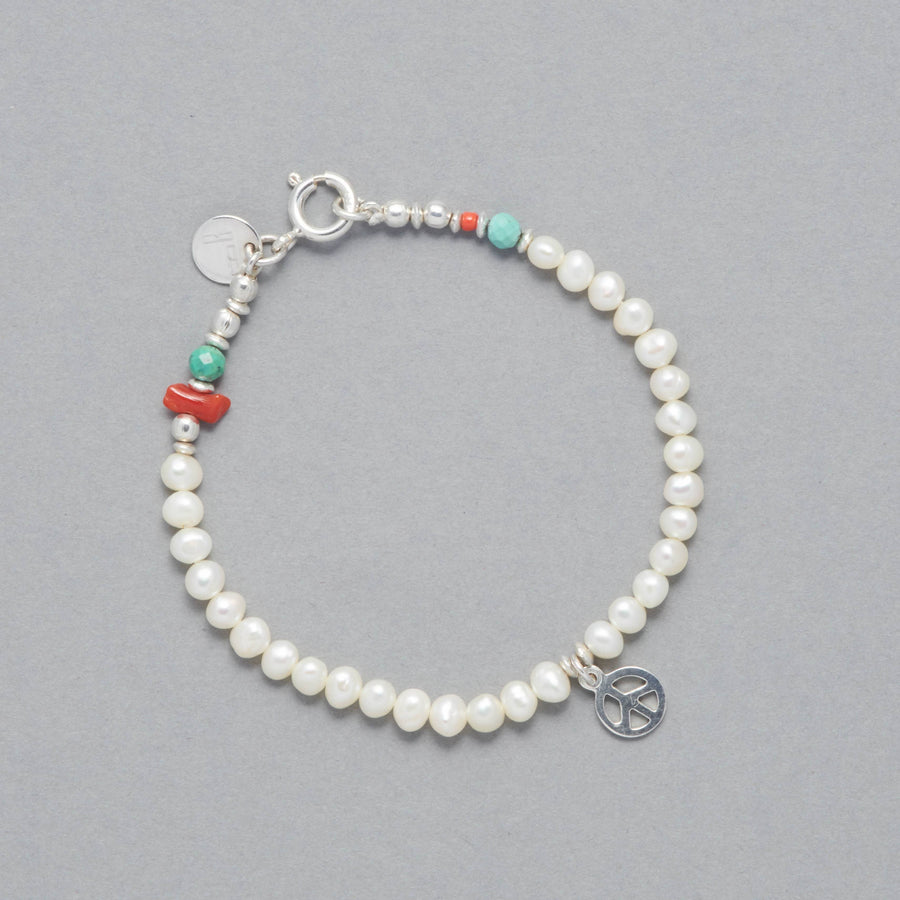 Product shot of the Marina Bracelet made with Cultured Freshwater white Pearls, faceted Turquoise, Sterling Silver Elements and a Peace Symbol Sterling Silver Peace Symbol Charm. 