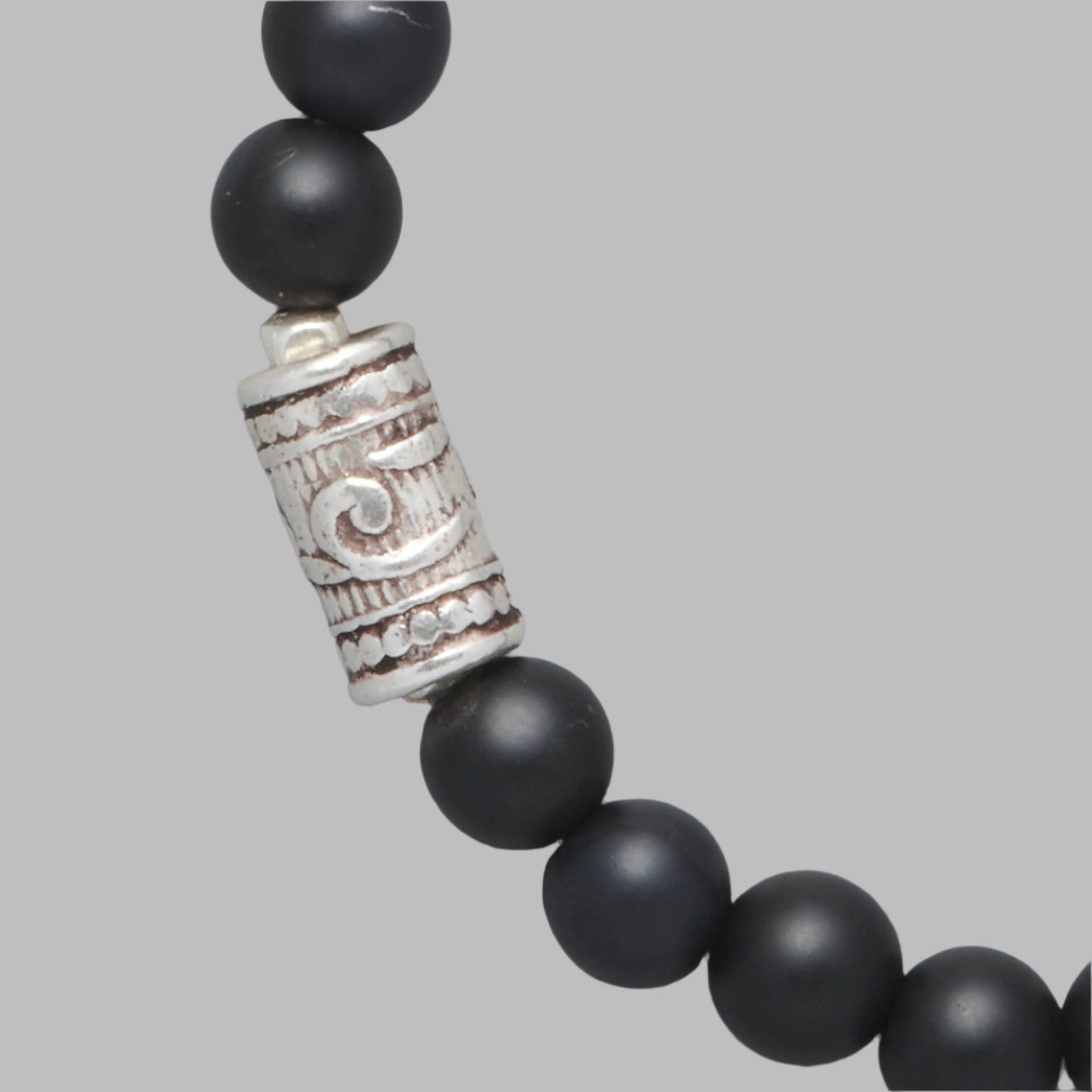 Detail shot of the Maxim Men Beaded Bracelet made with Mat Black Onyx and a Sterling Silver Element.