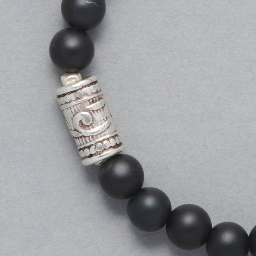 Detail shot of the Maxim Men Beaded Bracelet made with Mat Black Onyx and a Sterling Silver Element.