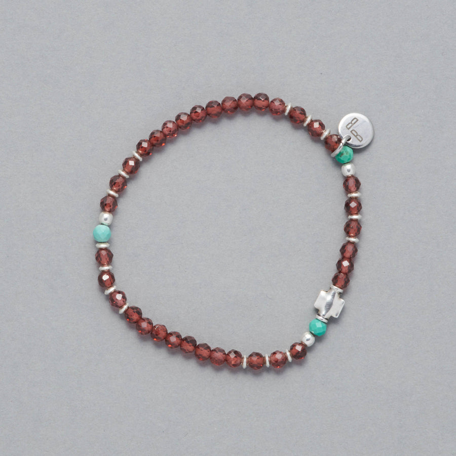 Product shot of the Sia Bracelet made with faceted Garnet, Turquoise and Sterling Silver elements.